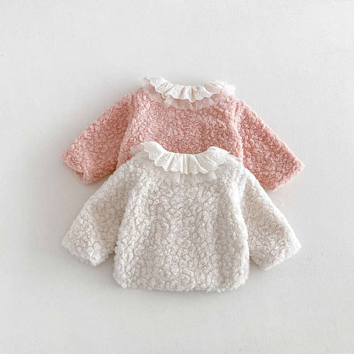 Back view of the pink and ivory sherpa jackets with lace and tulle collars