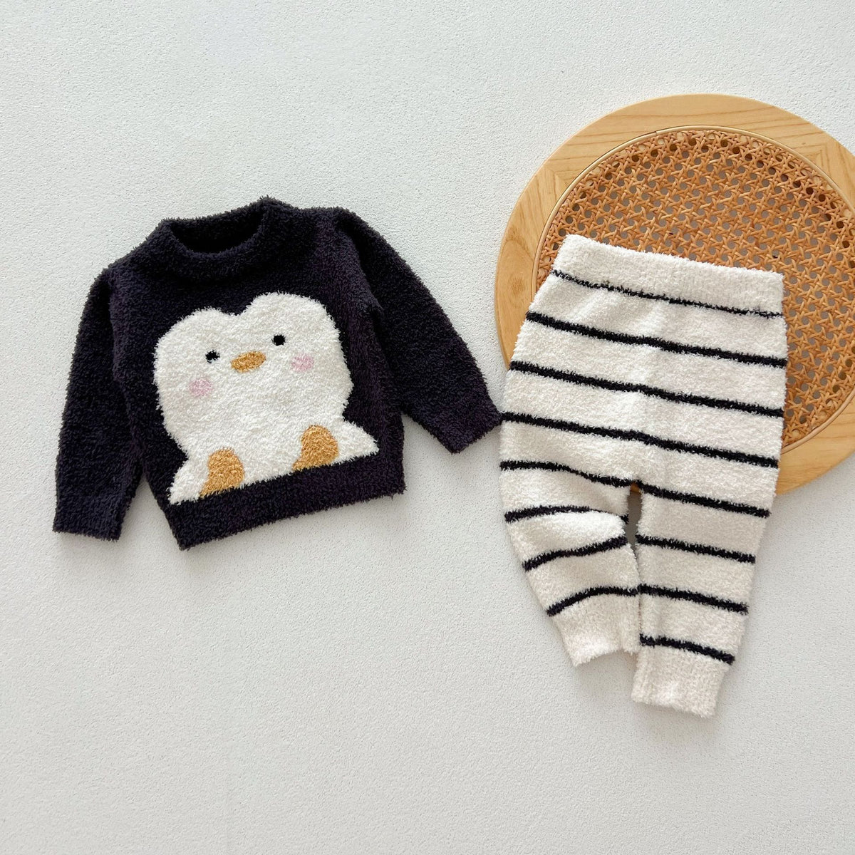 Navy penguin knit sweater with cream and black striped pants