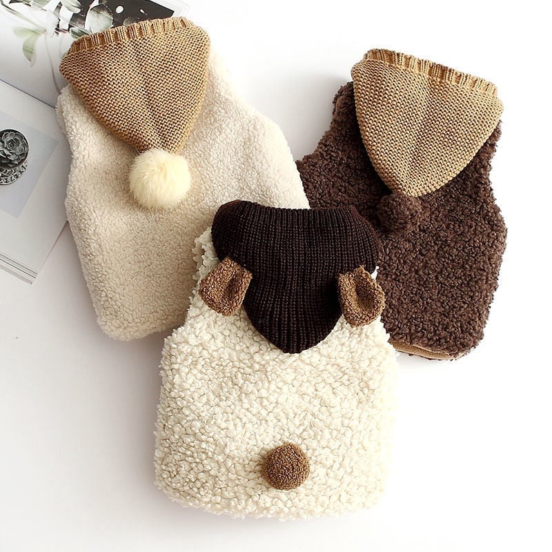 Back view of three hooded sherpa vests with pom-pom tails