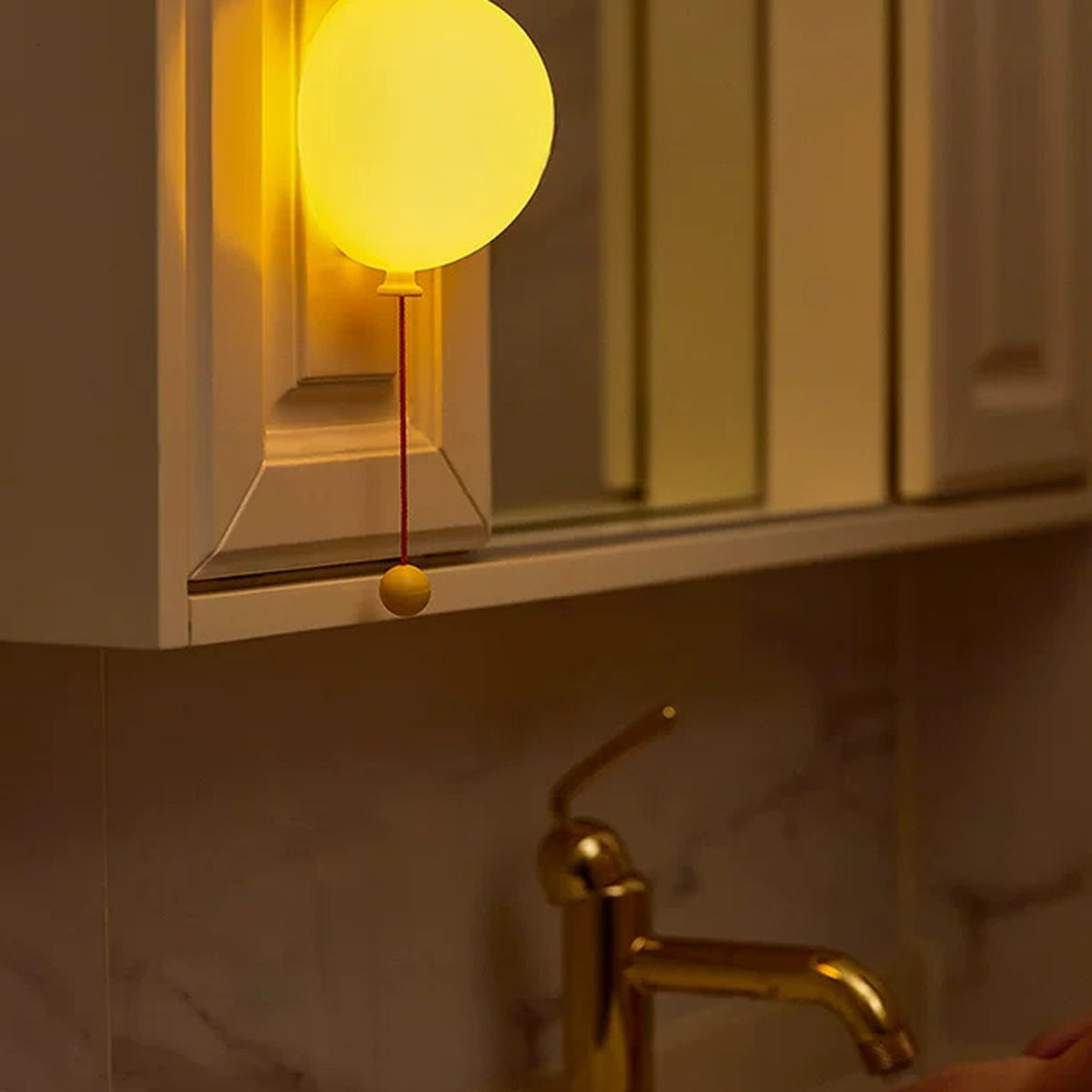 Balloon night light mounted inside a bathroom cabinet nook
