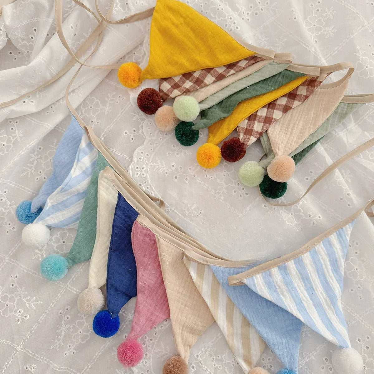 Close-up of muslin flags with gingham, stripes and fluffy pom-poms