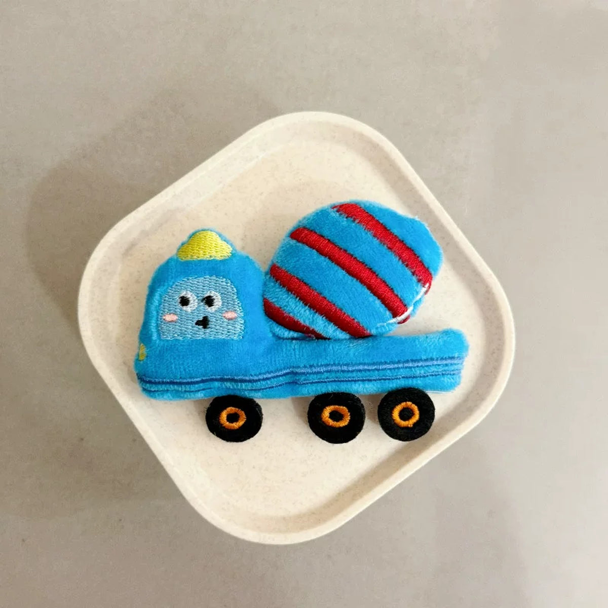 Close-up of the blue plush mixer truck charm