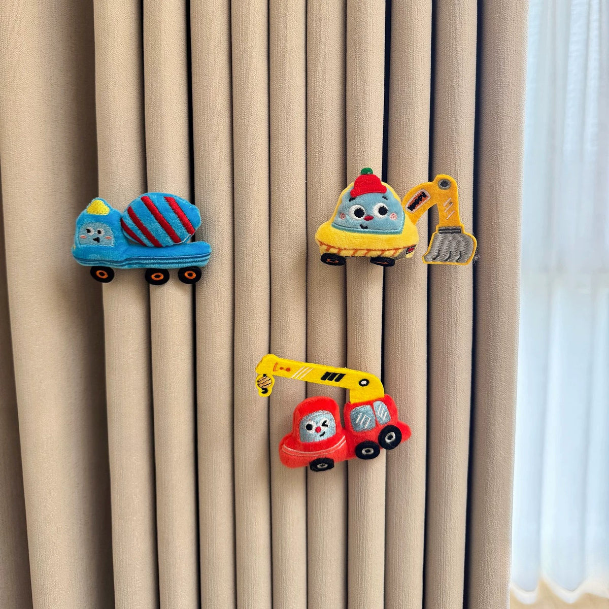 Mixer truck, excavator and crane plush pins on a curtain