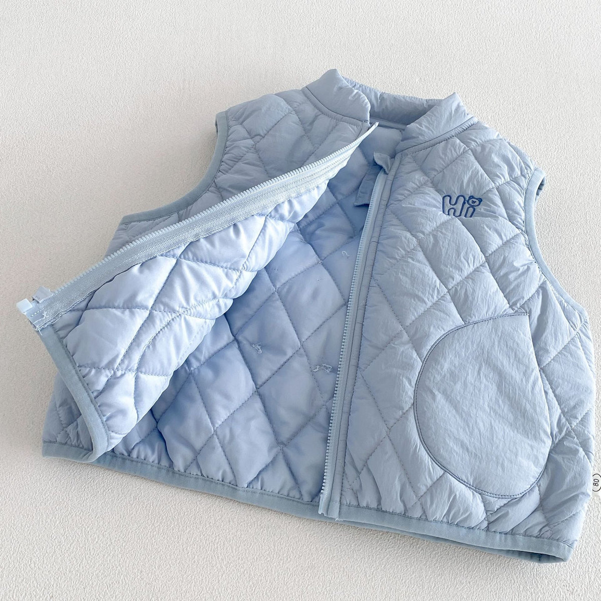 Sky blue vest opened to show the quilted lining and full zip