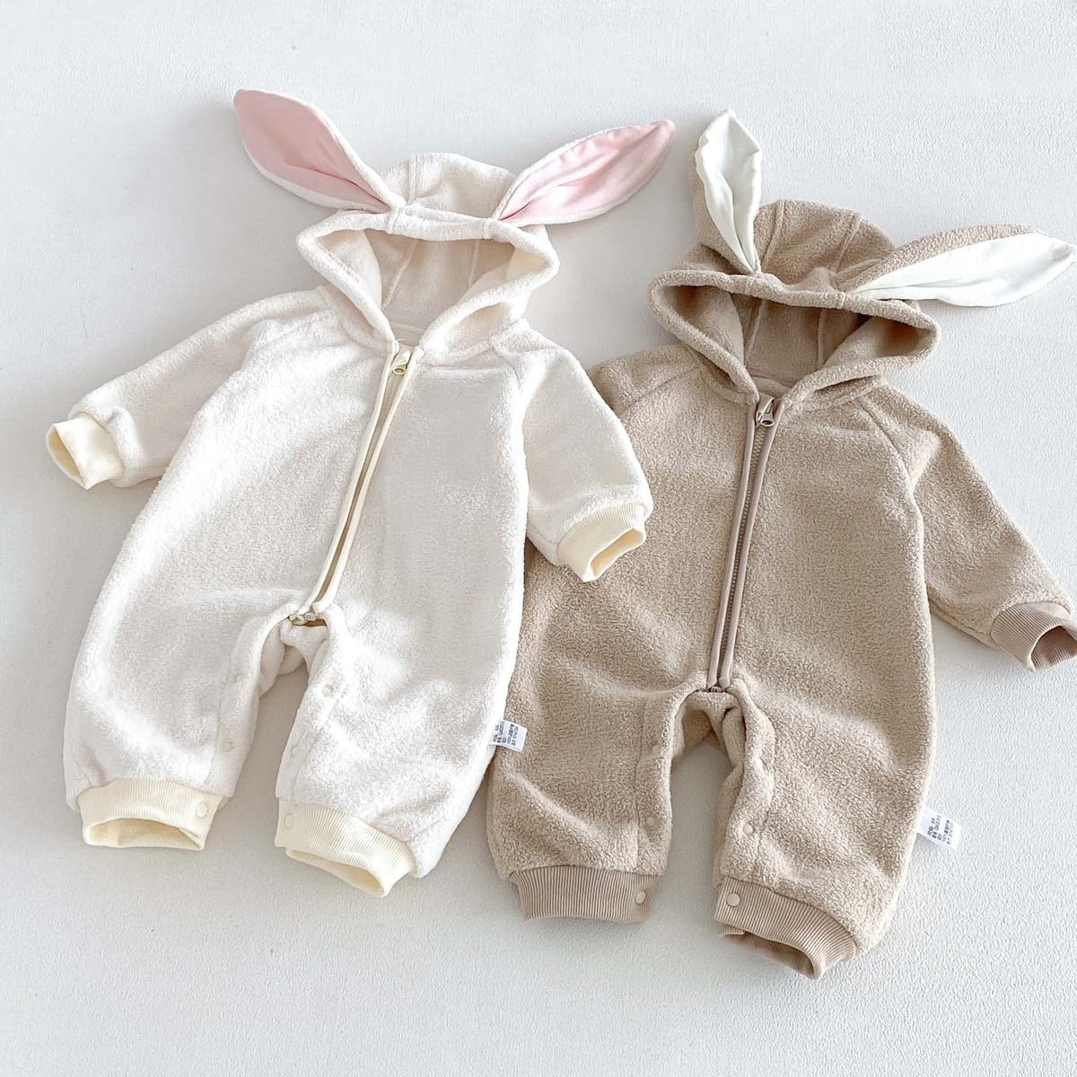 Ivory and latte zip-up bunny rompers side by side