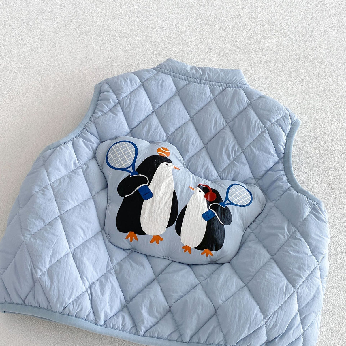 Close-up of the penguin tennis patch on the back of the sky blue vest