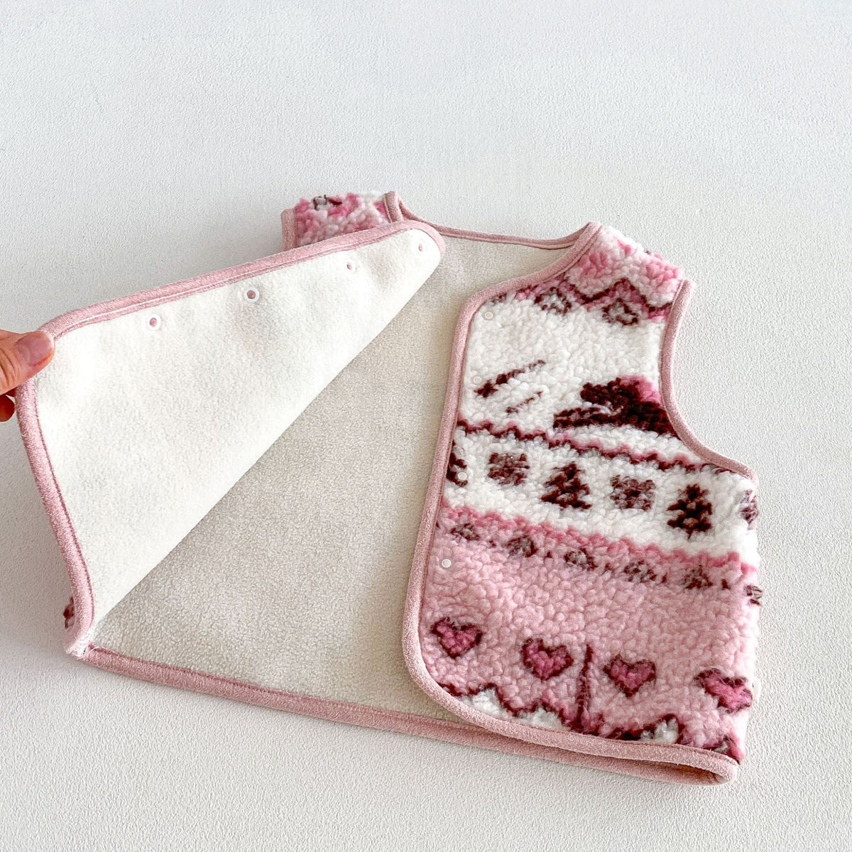 Pink fleece vest opened to show the soft plush lining and snap front