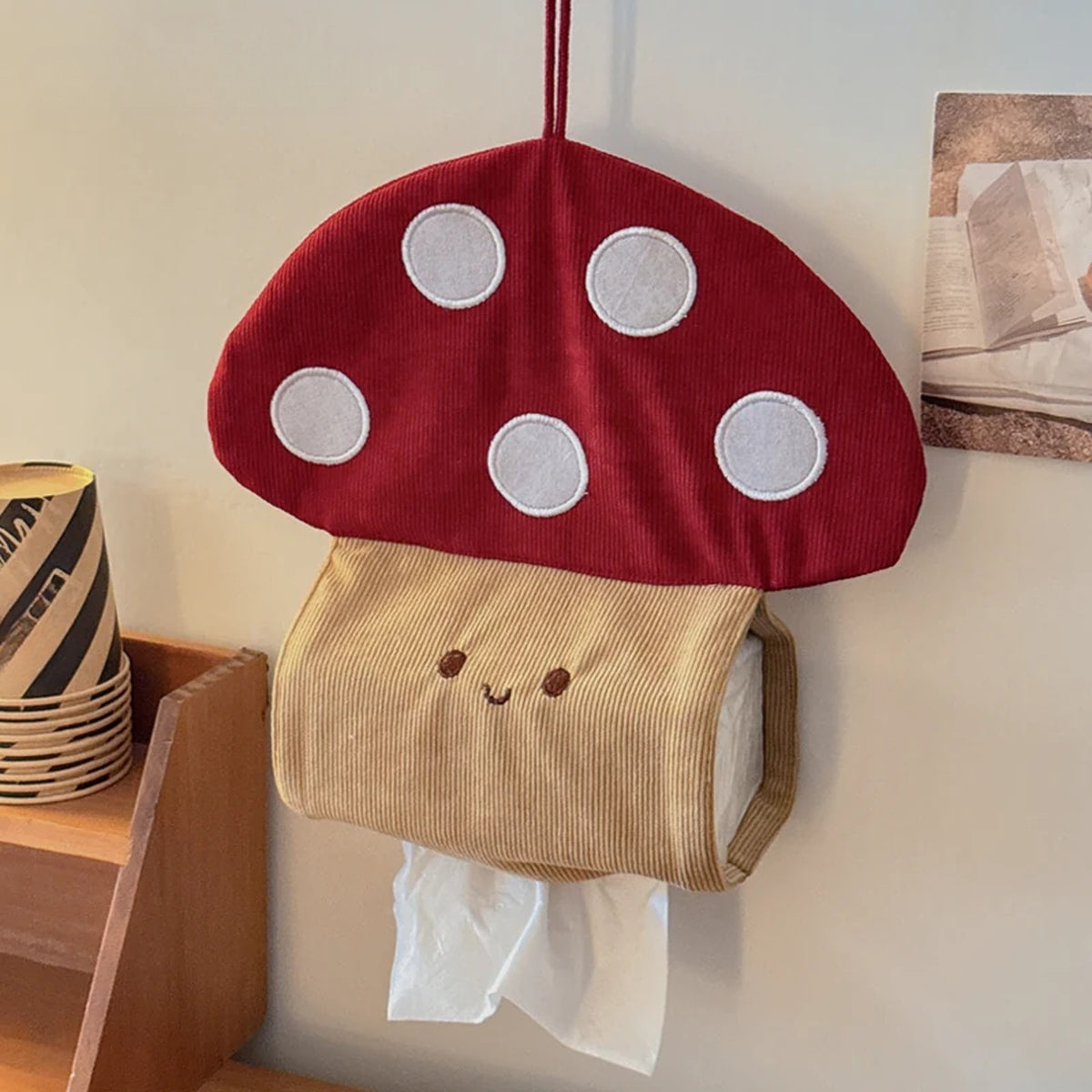 Smiling mushroom tissue holder with white spots, hung by its loop