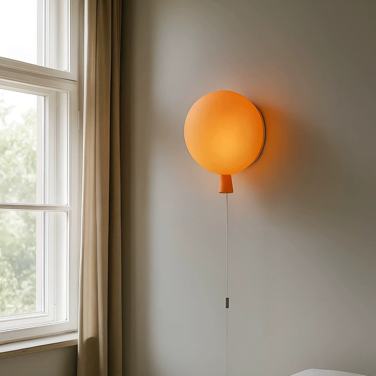 Frosted orange balloon wall lamp beside a window with linen curtains