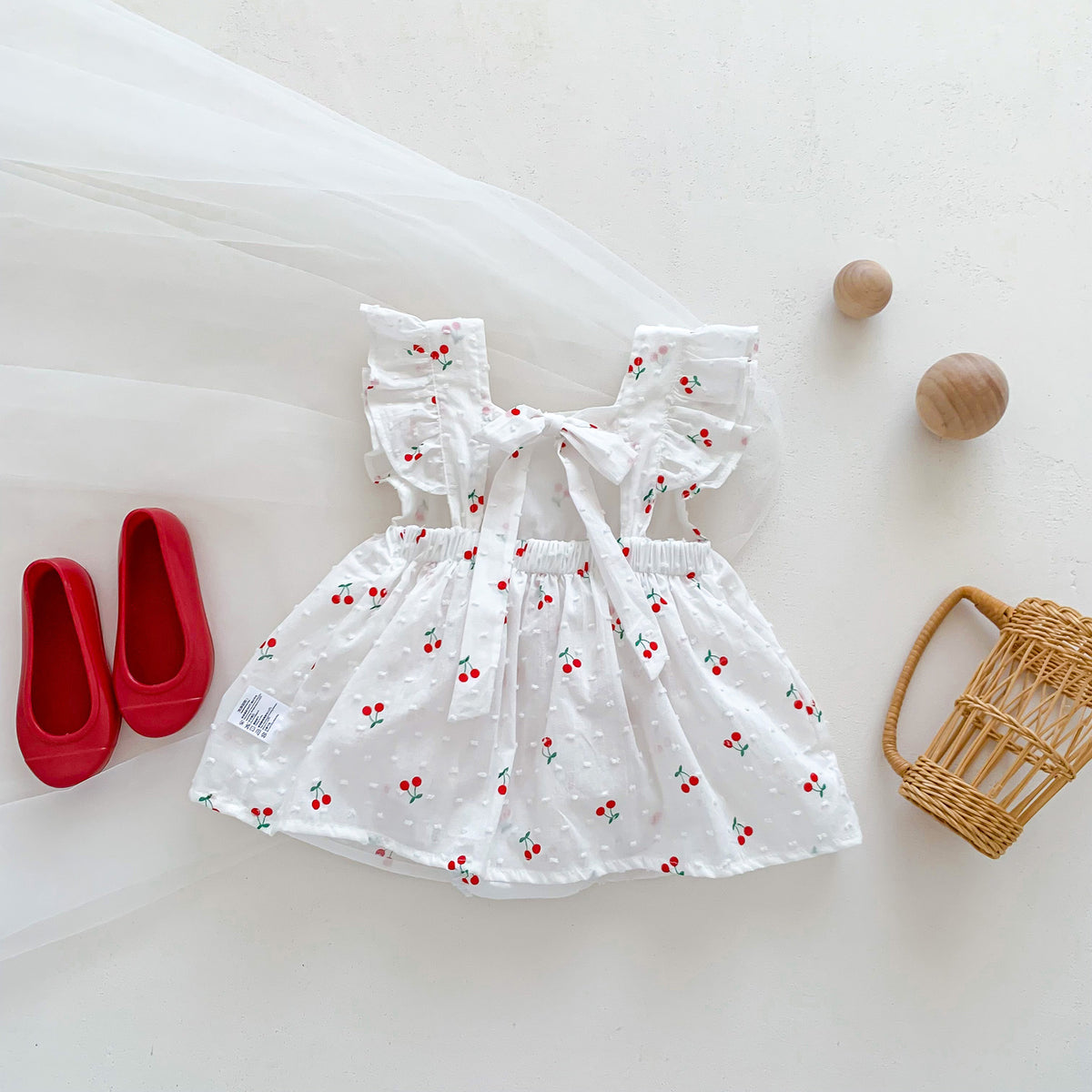 Cherry print flutter dress with swiss dot fabric styled with red shoes