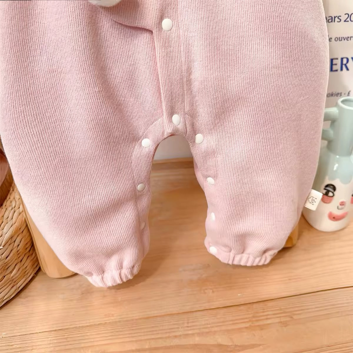 Pink baby jumpsuit leg snap closures for easy diaper changing