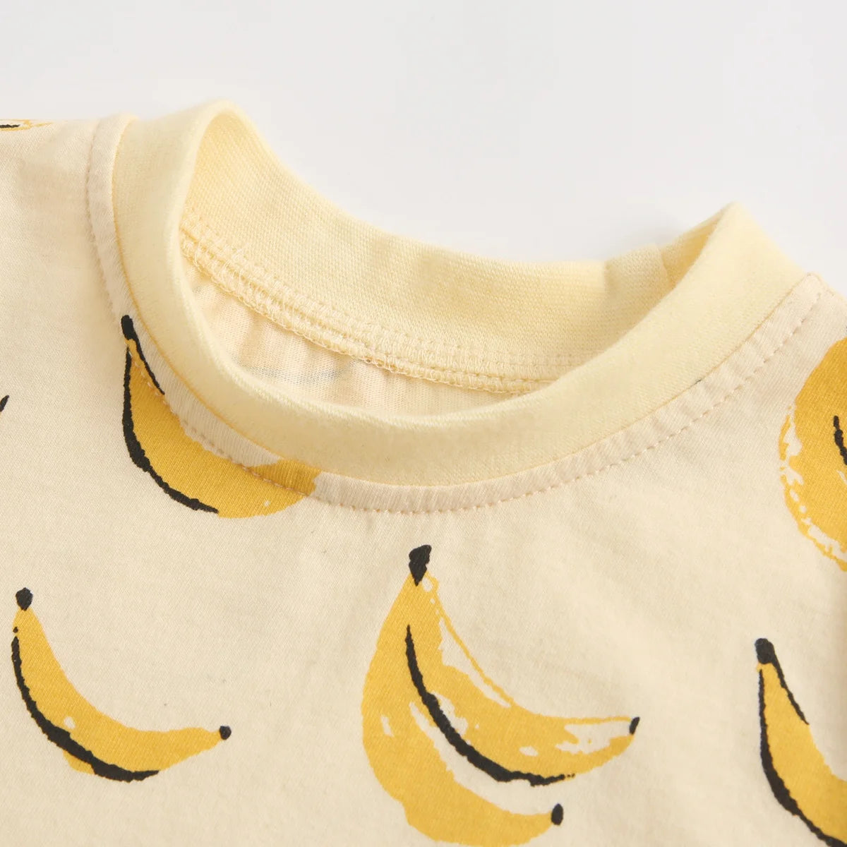 Banana print baby bodysuit crew neckline close-up detail