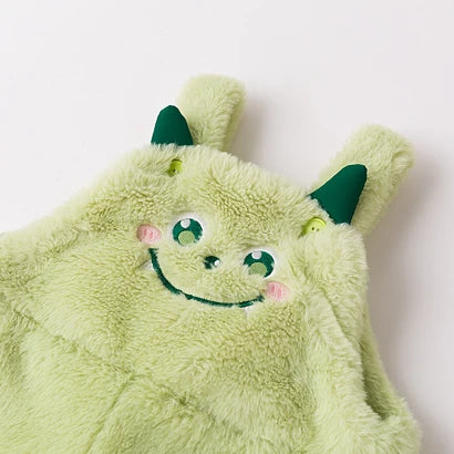 Close-up of the embroidered monster face and horns on green plush overalls