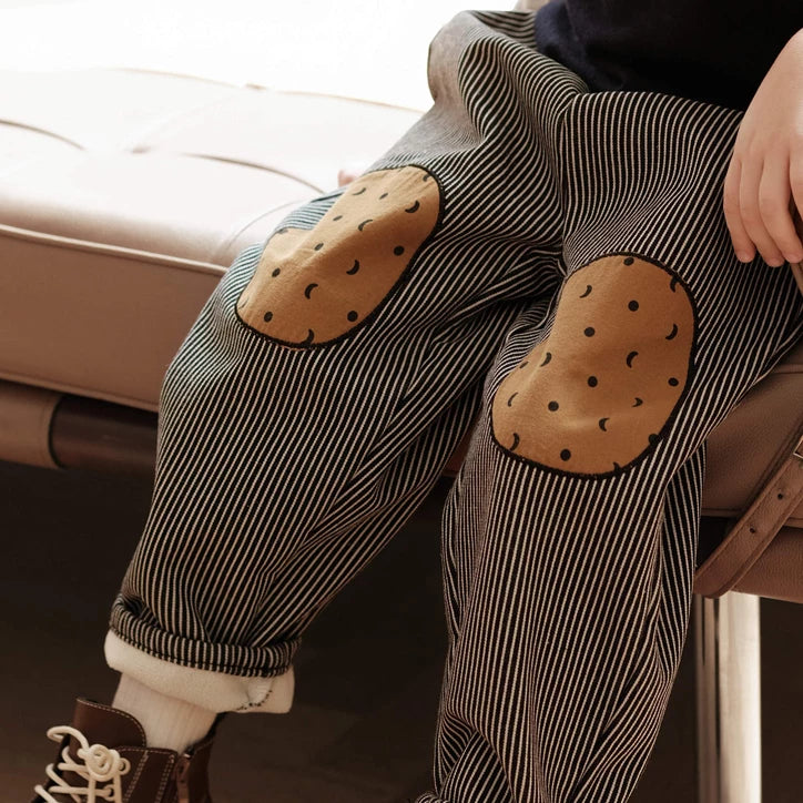 Close-up of dotted cookie knee patches on striped fleece-lined pants