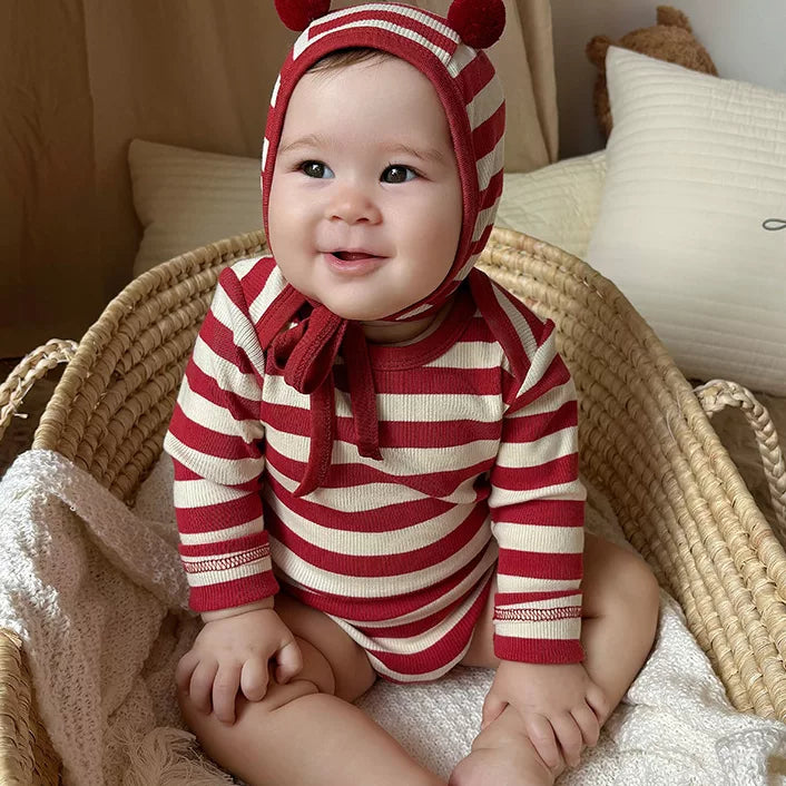 Smiling baby in a red and cream striped long sleeve bodysuit