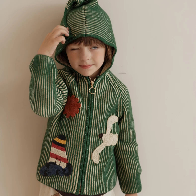 Child with the pointy pixie hood up on a green zip-up knit cardigan