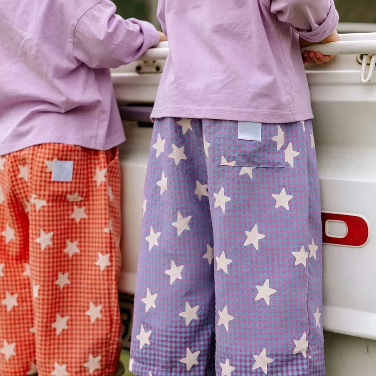 Back view of coral and lavender star gingham pants with elastic waist