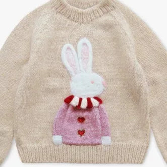 Front view of a cream raglan sweater with a pink bunny design