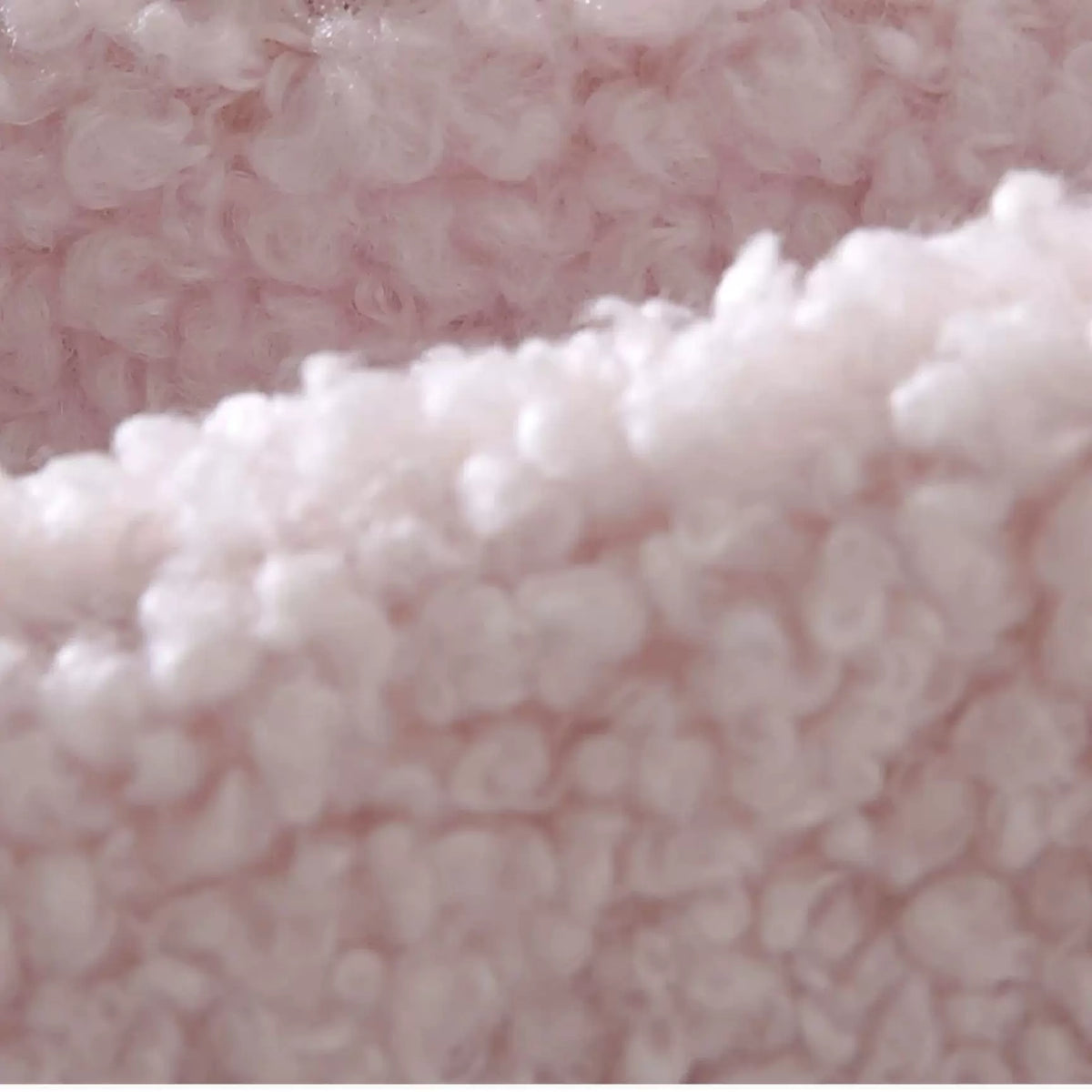 Close-up of the soft curly blush sherpa fleece