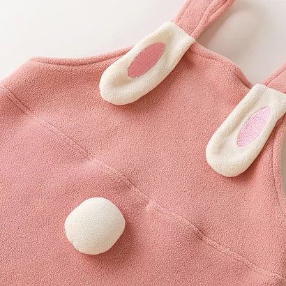 Back of rose fleece dungarees with bunny ears on the straps and a pompom tail