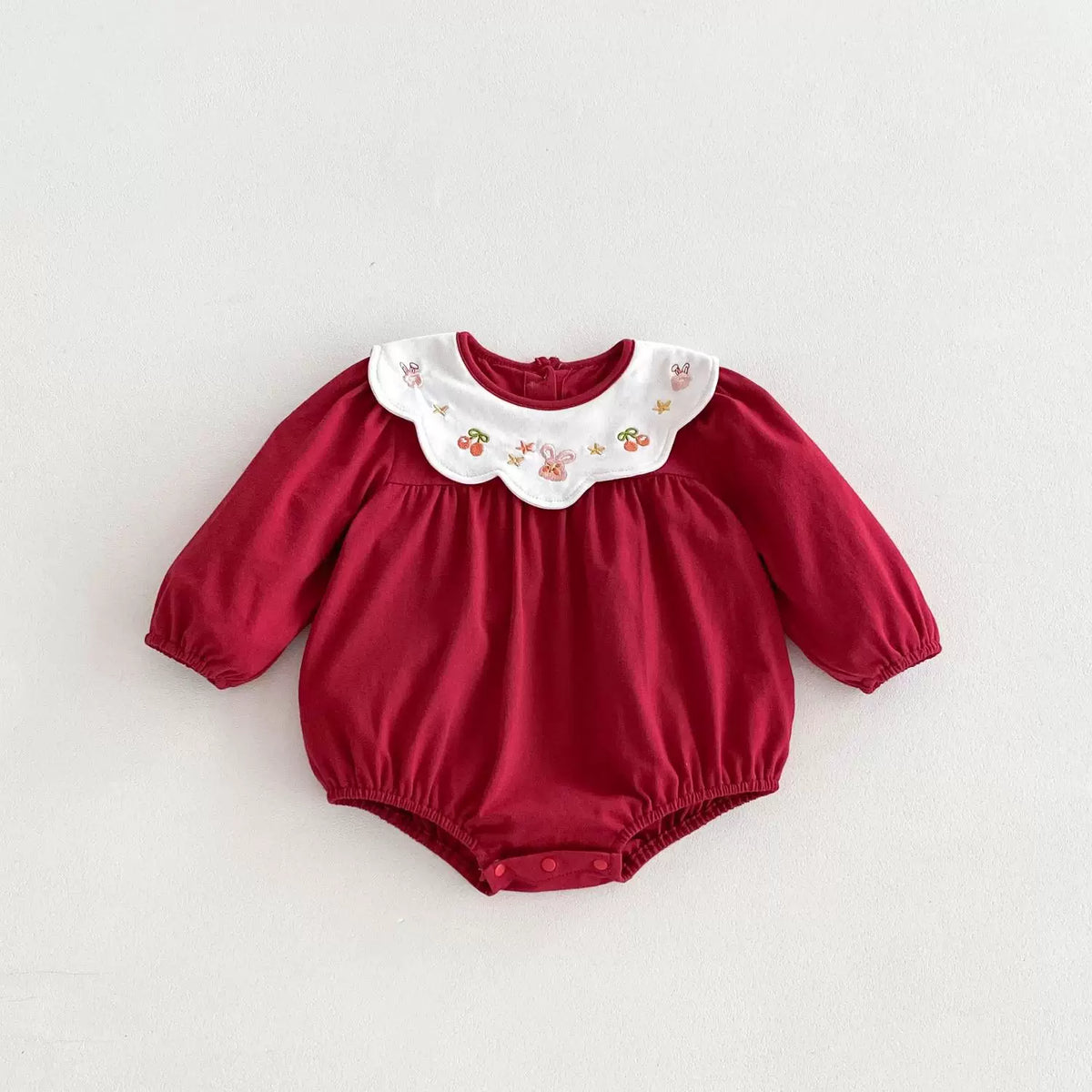 Berry red long-sleeve baby bodysuit on a white background