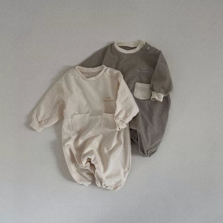Cream and stone grey pocket rompers laid together