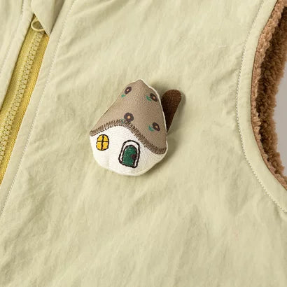 Close-up of the zip front and plush house appliqué on the sage romper