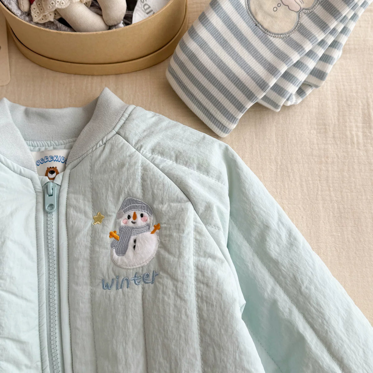 Close-up of snowman winter embroidery and zip on the front