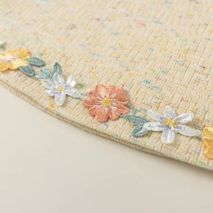 Close-up of the embroidered daisy and blossom hem trim