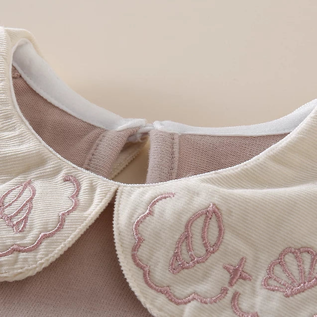 Close-up of the embroidered seashell Peter Pan collar