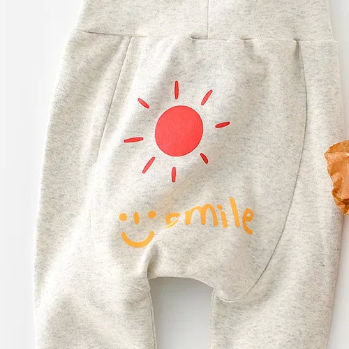 Oatmeal baby pants with a red sun and smile print