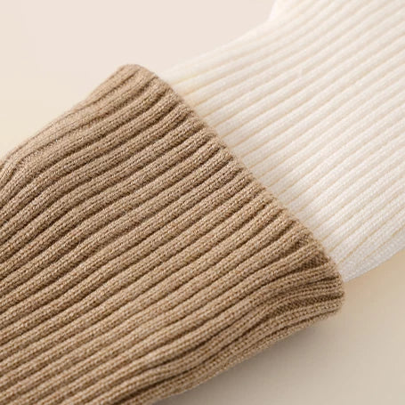 Close-up of camel ribbed cuff on cream knit leggings