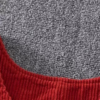 Close-up of the button shoulder straps on red corduroy overalls