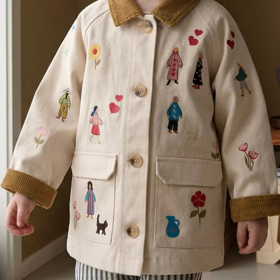 Child wearing a cream embroidered chore jacket with corduroy collar and cuffs