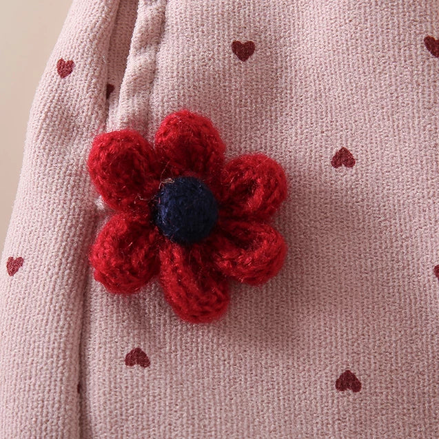 Red crochet flower detail on pink heart-print toddler dungarees