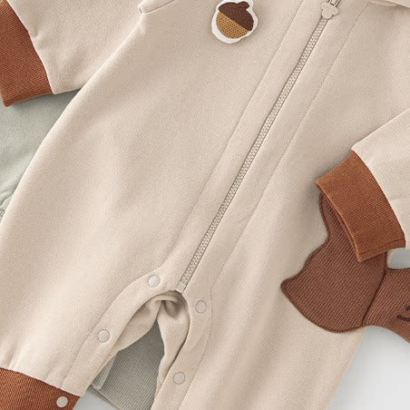 Oatmeal squirrel romper lying on the sage star romper, zip front detail