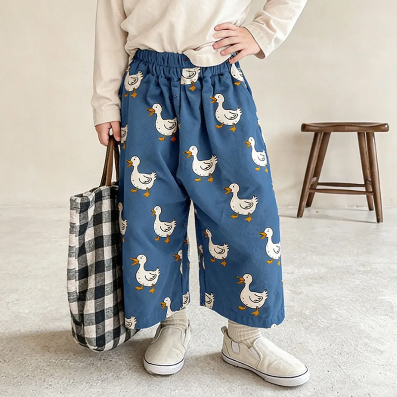 Child wearing blue wide-leg pants with white duck print