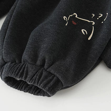 Close-up of elastic cuffed ankle and embroidered bear on charcoal kids pants