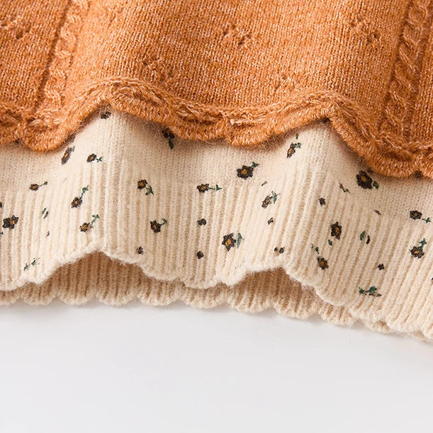 Scalloped hem and cable detail on the knit vest layer