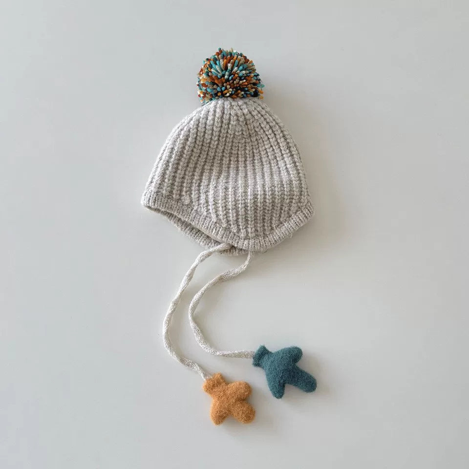 Oat chunky knit toddler earflap hat with confetti pom-pom and mitten charms, flat lay