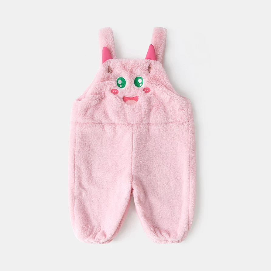 Pink plush kids overalls with a smiling monster face and little horns, flat lay