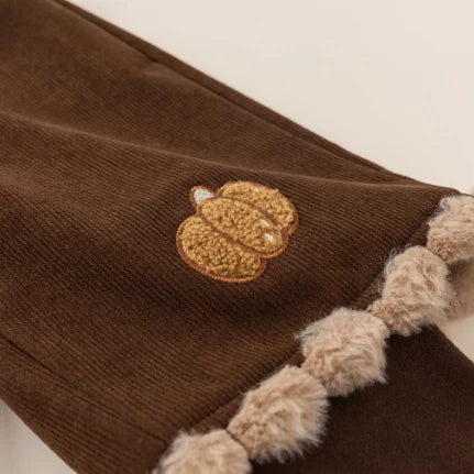 Embroidered pumpkin detail on brown corduroy pants