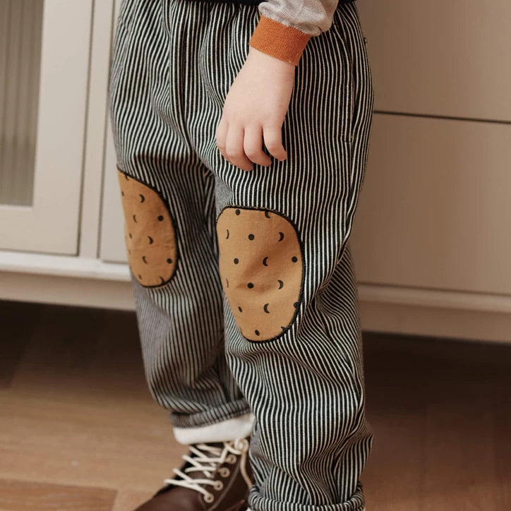 Relaxed fit striped kids pants worn with brown lace-up boots