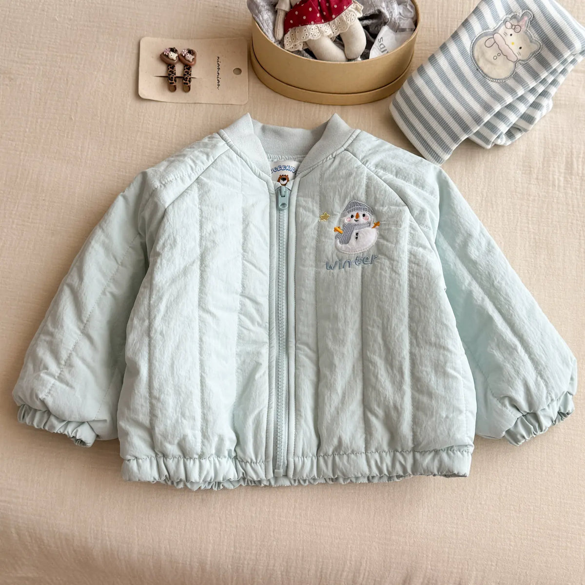 Mint quilted toddler jacket laid flat with ribbed collar