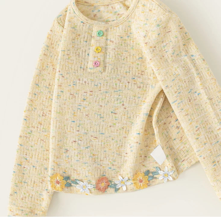 Textured yellow girls tee with colourful flecks and a flower trim hem