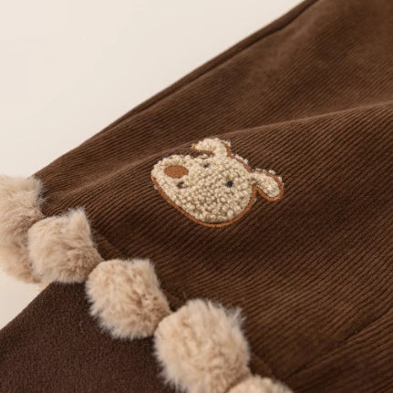 Embroidered teddy bear and fluffy pompom hem detail