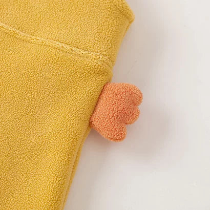 Close-up of the soft fleece and tail detail on mustard kids overalls