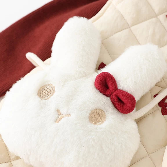 Close-up of the fluffy white bunny crossbody bag with red bow