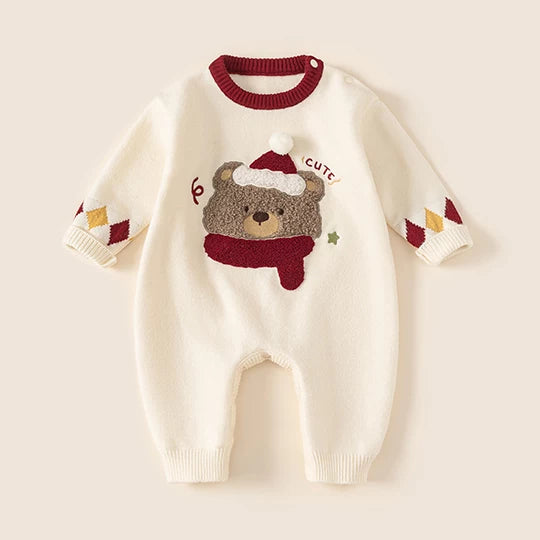 Cream knit baby romper with fluffy bear in Santa hat and red scarf, flat lay