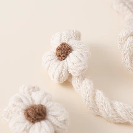 Close-up of the crochet flower and braided tie on an oat knit bonnet